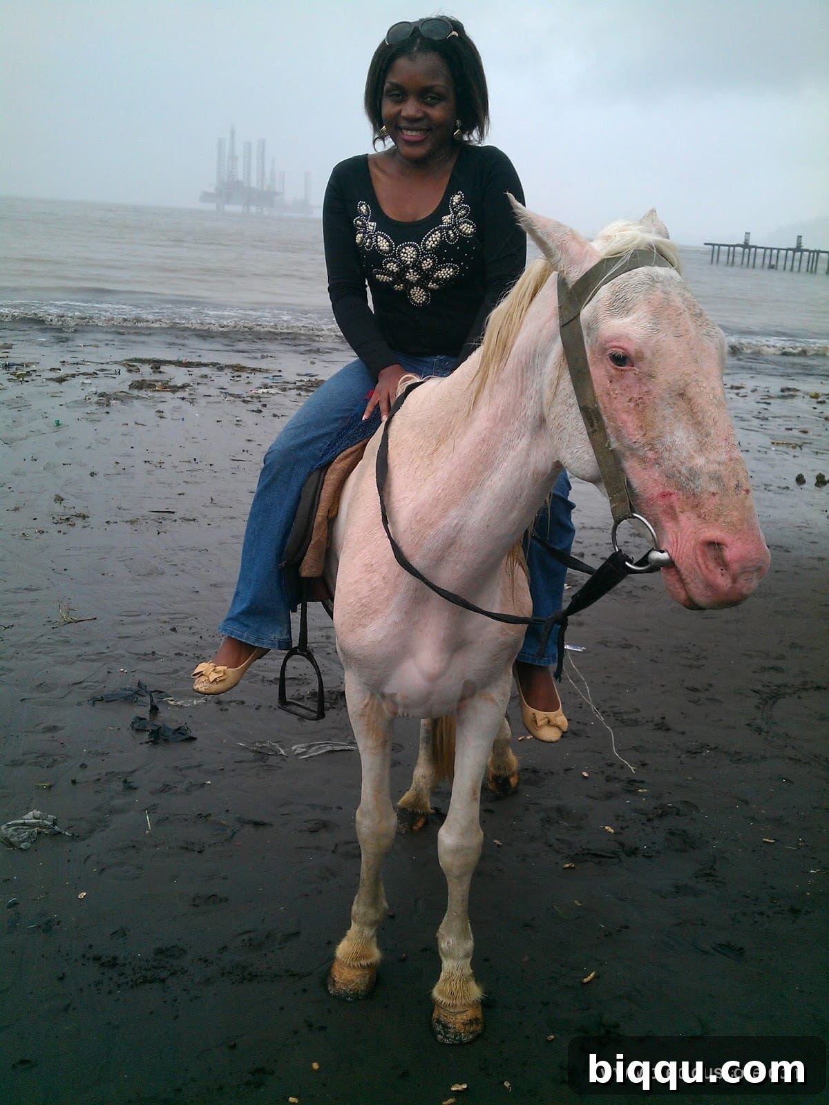 A horse rider on the black sands of Limbe beach.