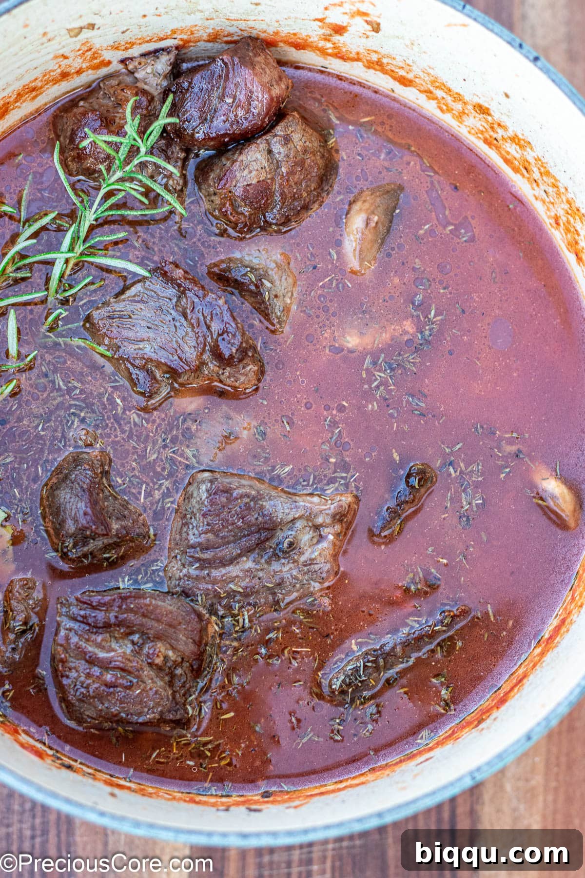 Hearty Beef Stew 9 Dutch oven with beef, broth, and crushed tomatoes simmering.