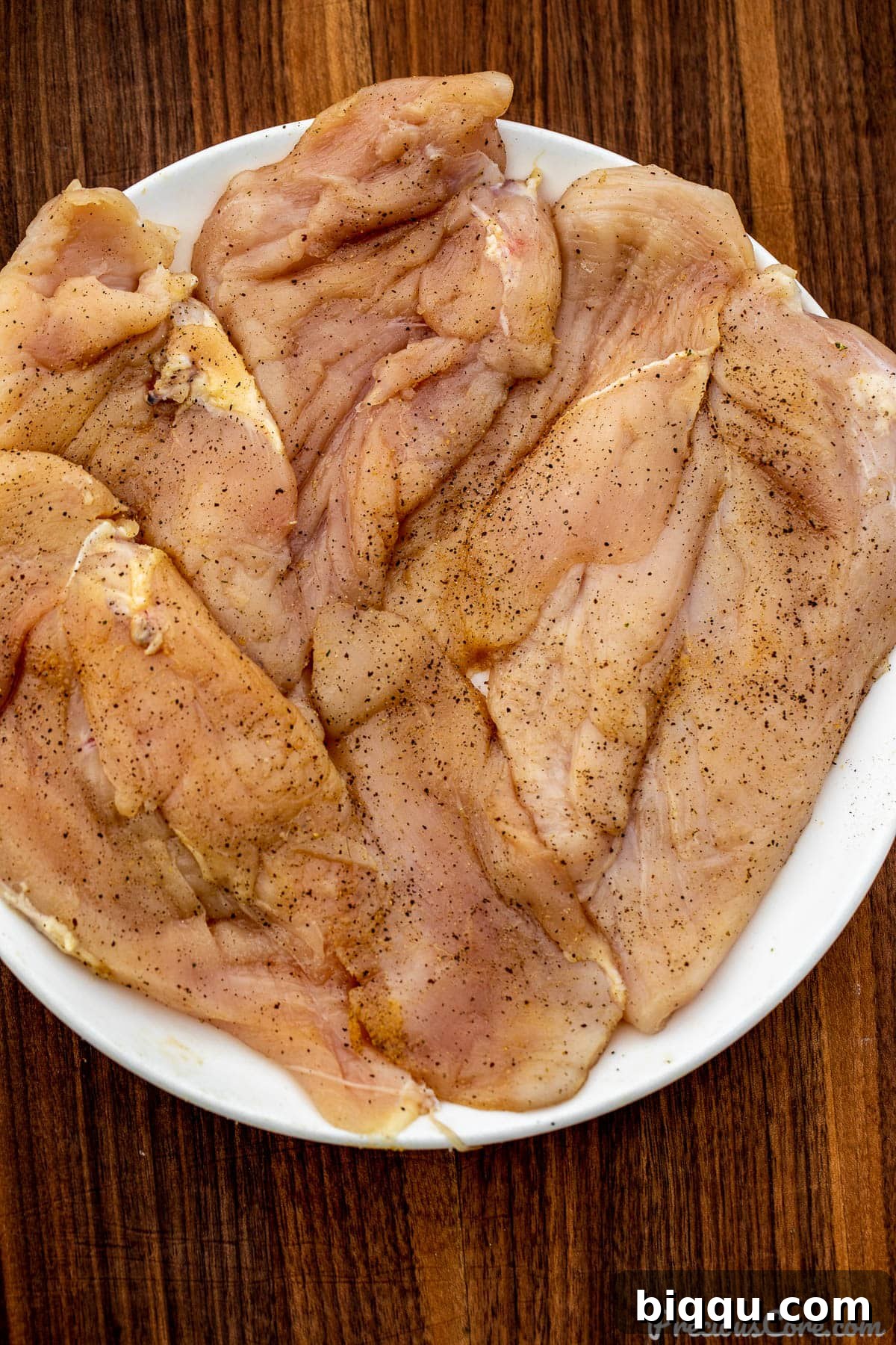 Chicken breasts seasoned with salt, pepper, and chicken bouillon powder, ready for searing.