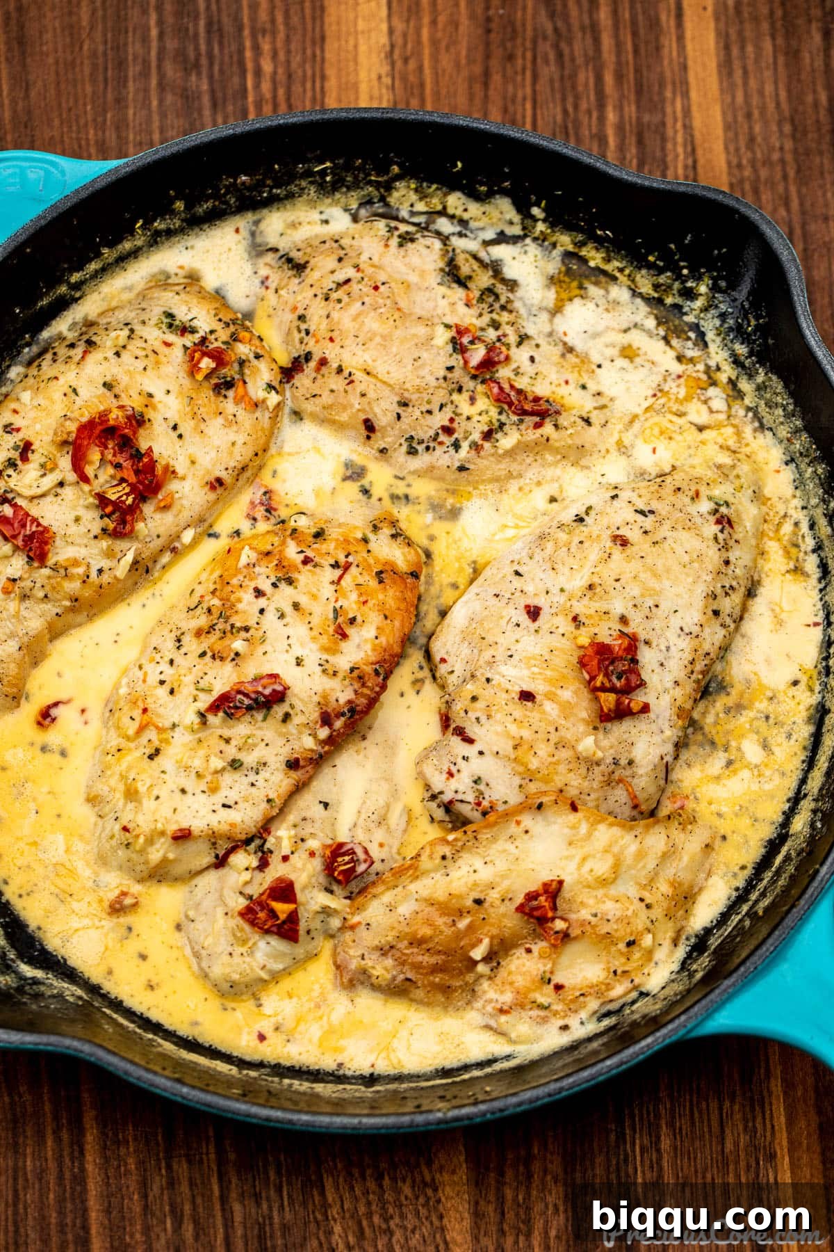 Marry Me Chicken simmering in a rich, creamy sun-dried tomato sauce within a large skillet.