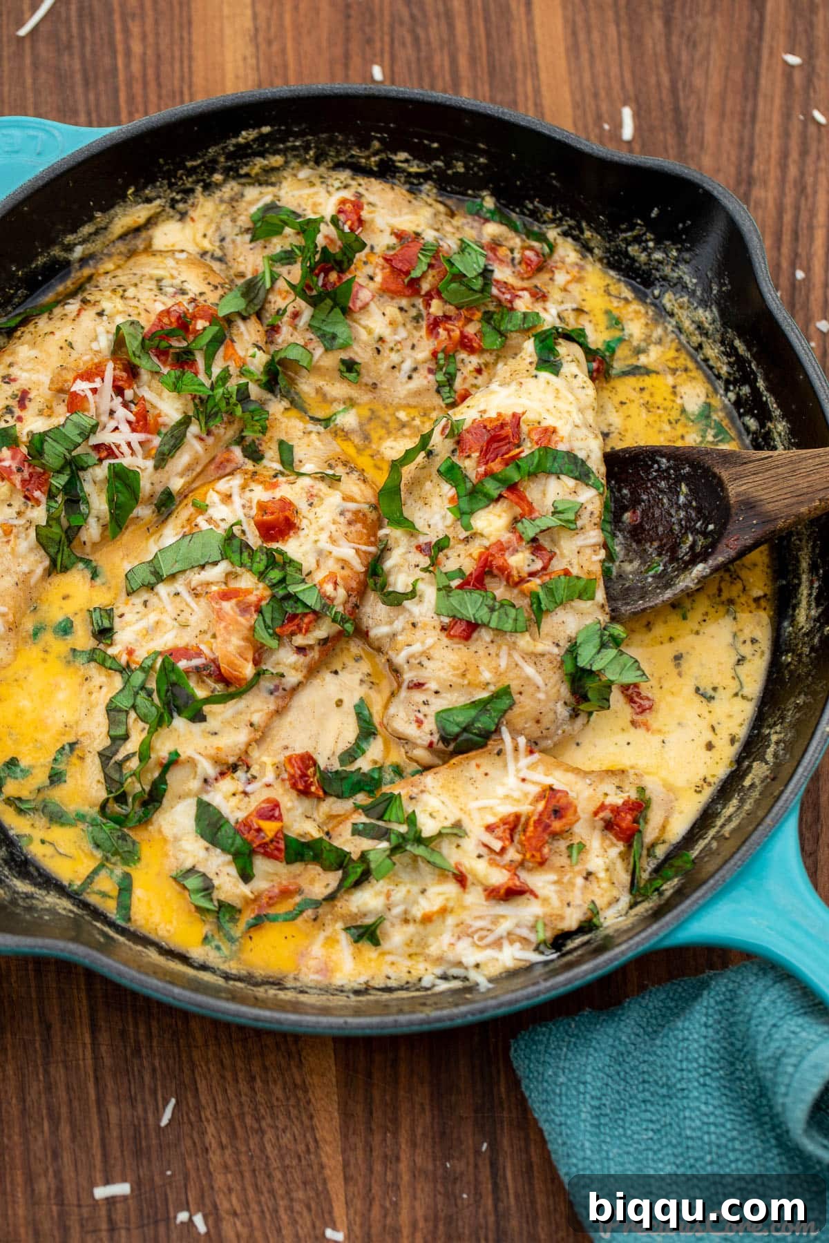 Marry Me Chicken topped with a generous sprinkle of parmesan cheese and fresh basil leaves.