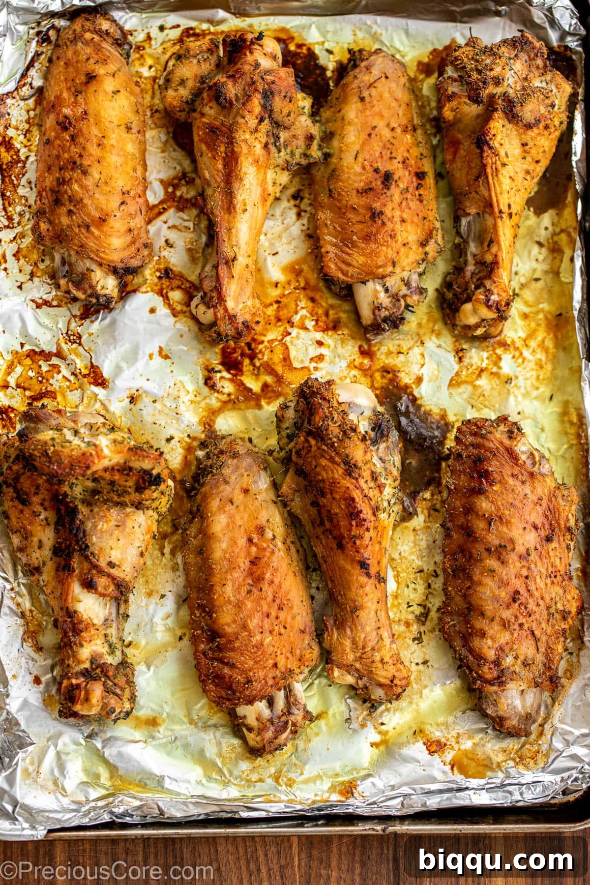 Golden brown, crispy roasted turkey wings on a baking sheet, fresh out of the oven.
