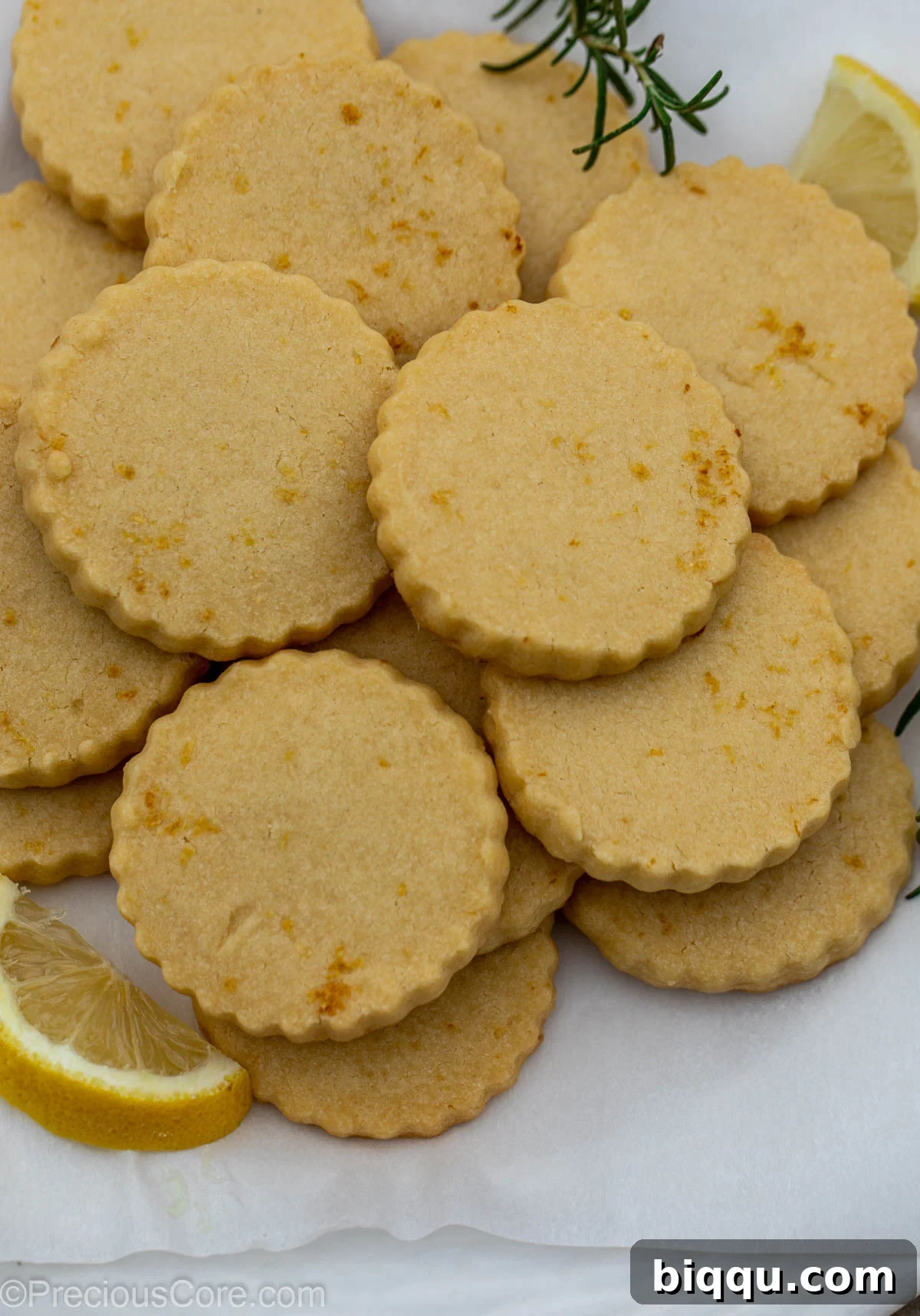 Baked lemon shortbread cookies cooling on parchment paper on a wire rack.