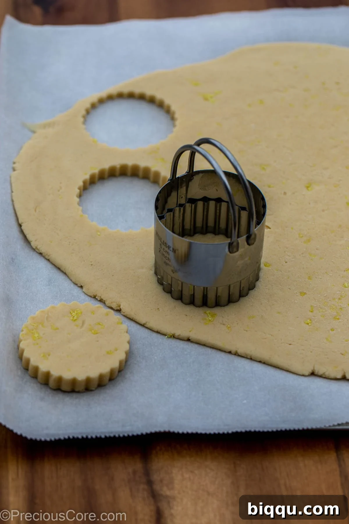 A 2-inch circular cookie cutter positioned on the chilled shortbread dough, ready for cutting.