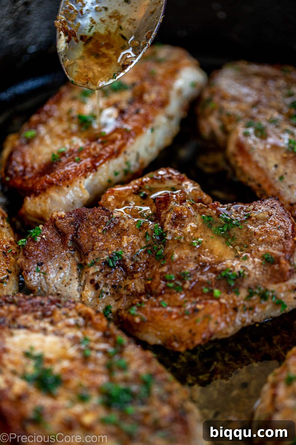 Garlic butter sauce spooning over pork chops