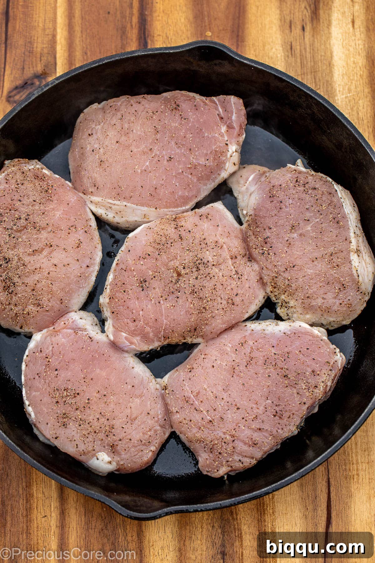 Pork chops in a cast iron skillet.