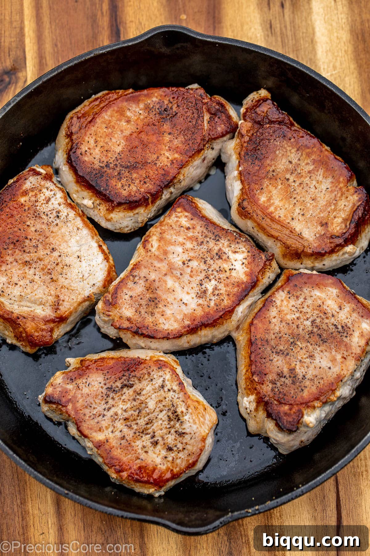 Seared pork chops in a cast iron pan.