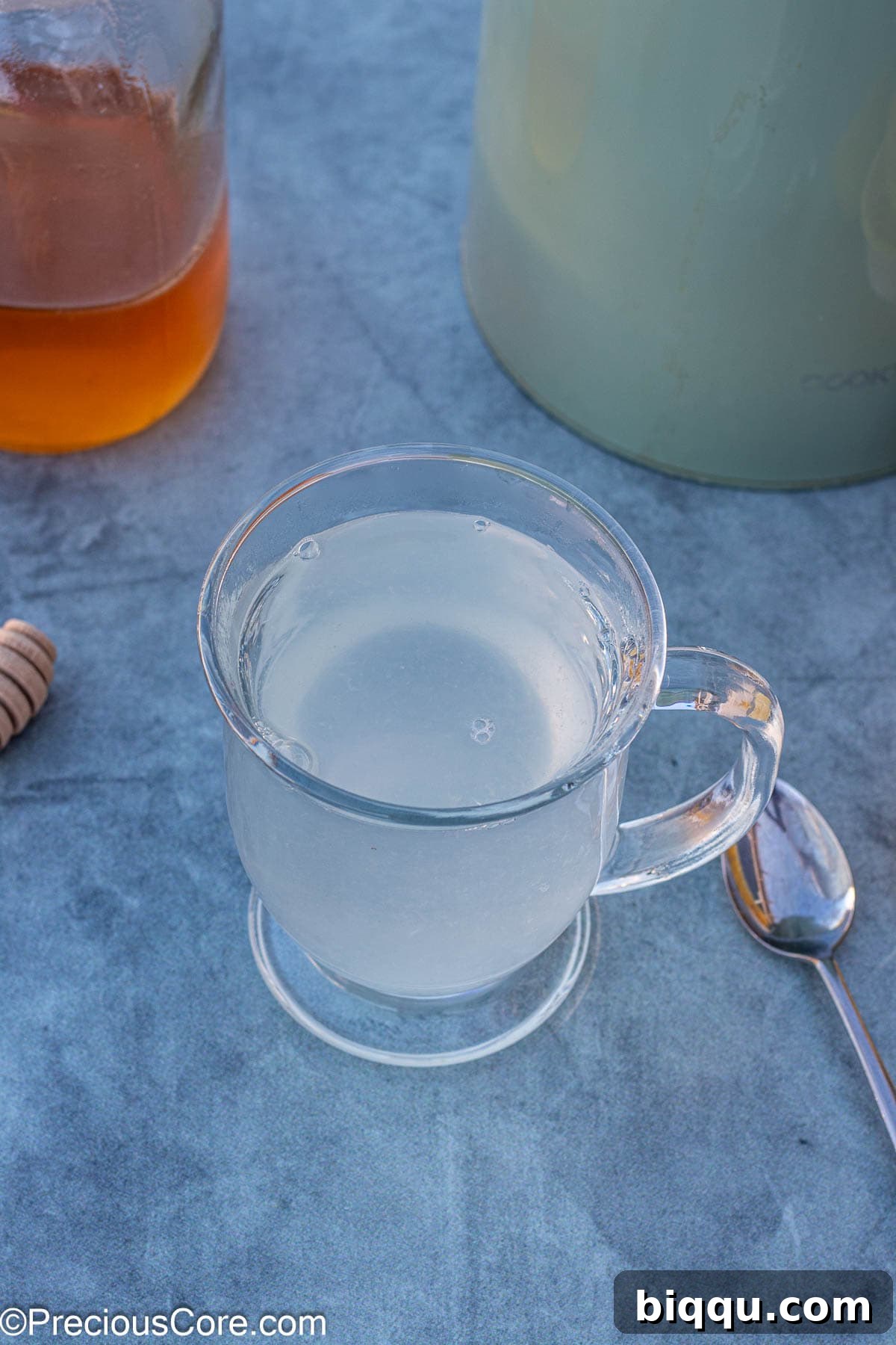 A mug filled with hot water and freshly squeezed lemon juice, ready for the next ingredient.