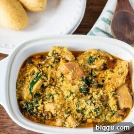 A steaming bowl of vibrant Egusi Soup, garnished with greens, inviting diners to experience its rich African flavors.