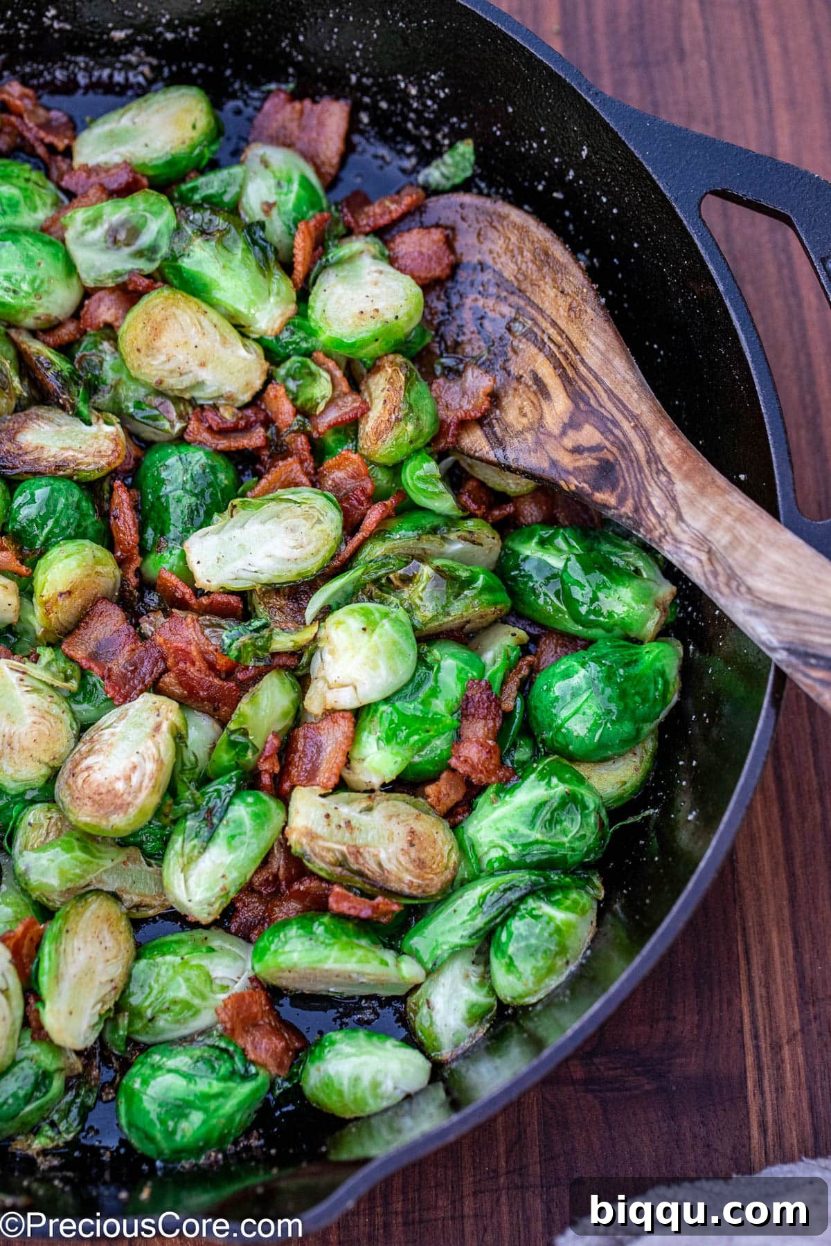 Cooked bacon with Brussels sprouts in a skillet.