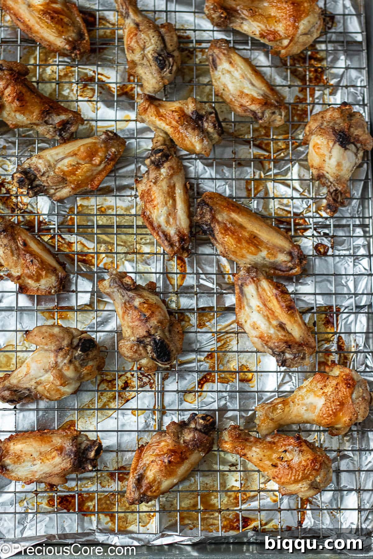 Crispy, golden-brown baked chicken wings cooling on a baking rack after cooking.