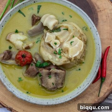 Bowl of pepper soup sitting on a round platter.