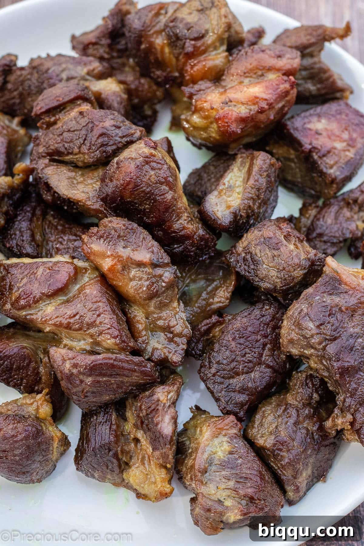 Fried beef pieces on a white plate, browned to perfection.