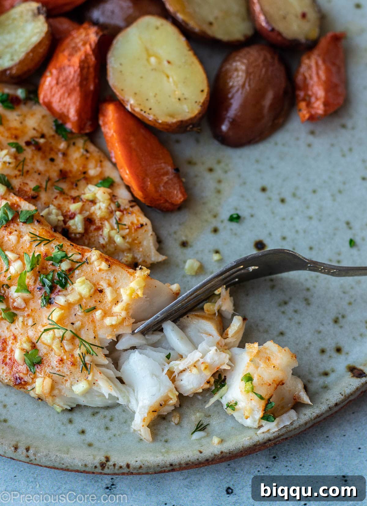 A generous serving of flaky baked tilapia on a clean white plate, garnished with fresh herbs, ready to be enjoyed.