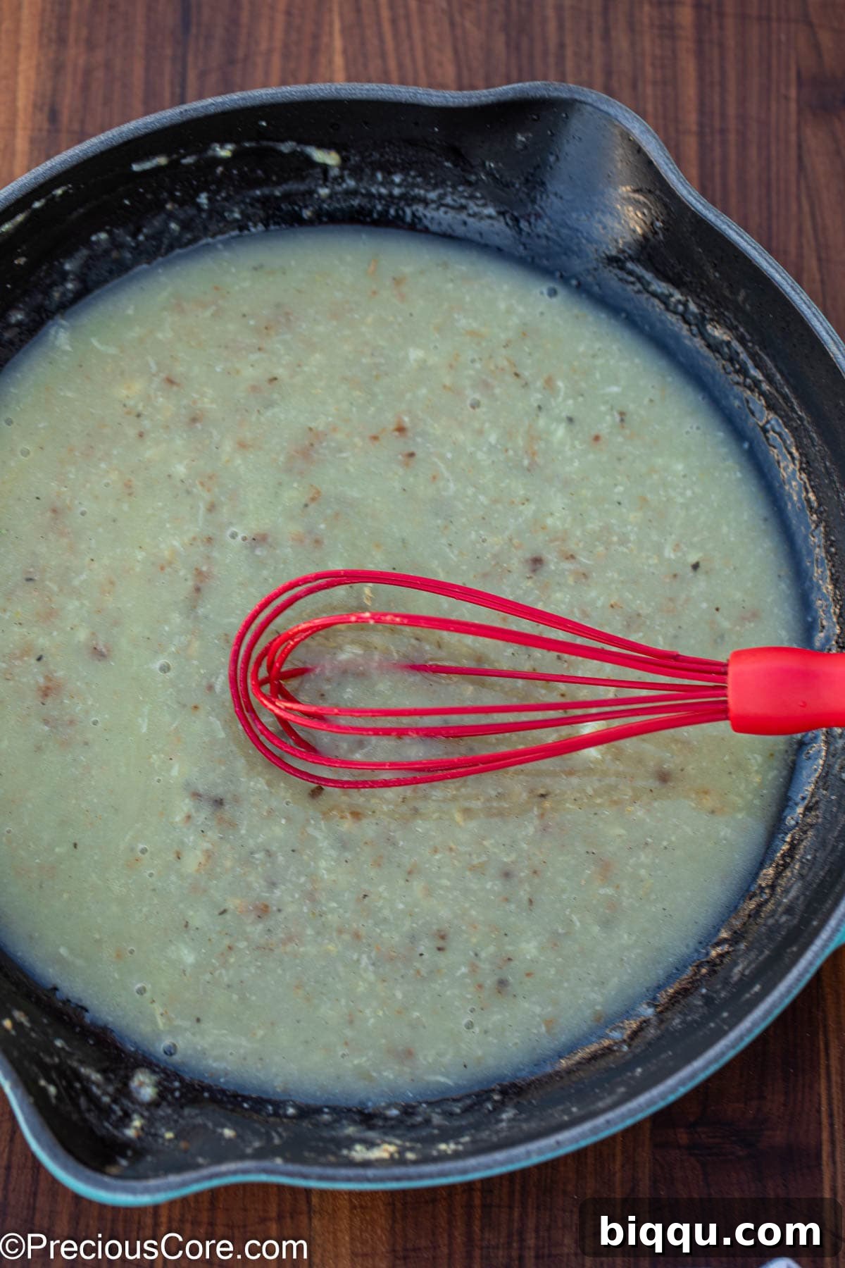Silken Fish Delight 8 A whisk smoothly blending white sauce ingredients in a pan as it thickens to a creamy consistency.
