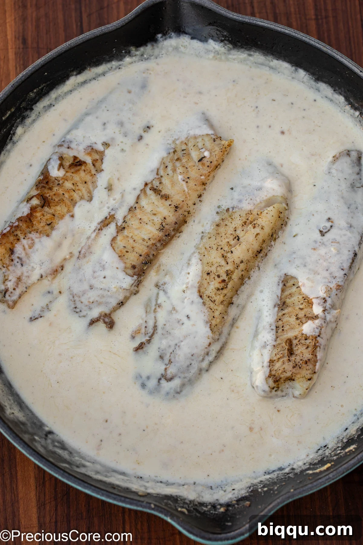 Silken Fish Delight 10 Tilapia fillets gently simmering in the creamy white sauce, absorbing the rich flavors.