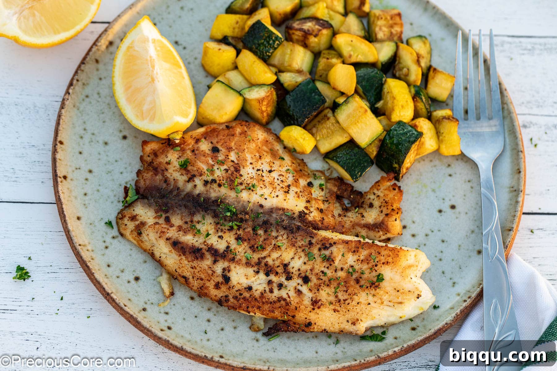 Landscape image of lemon pepper tilapia with vegetables.