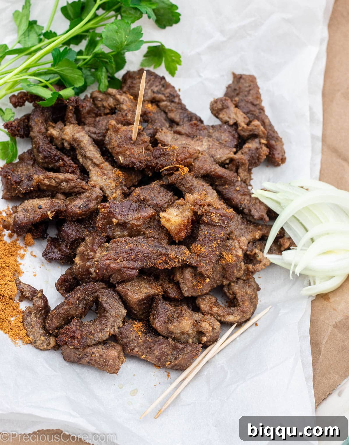 Cameroonian grilled meat on parchment paper, served with onions and soya pepper.