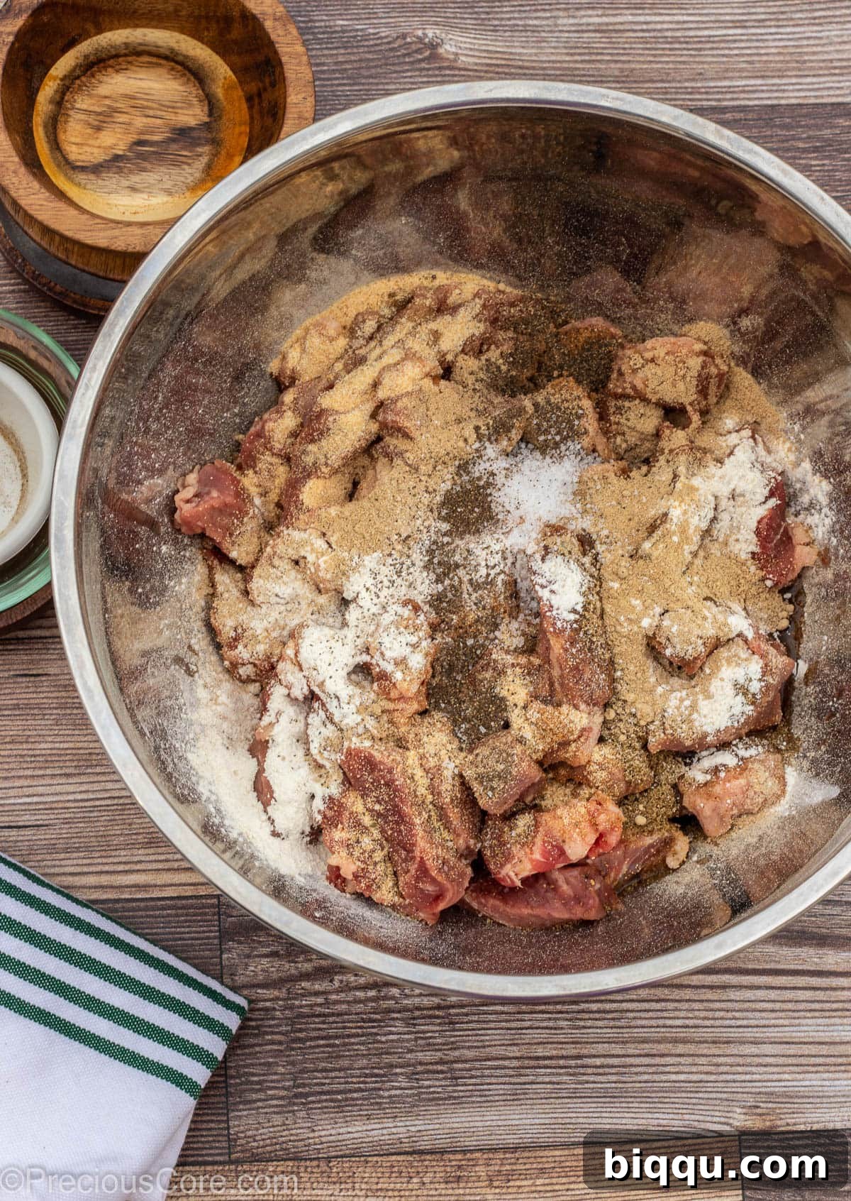 Beef in a bowl with oil and spices on top.