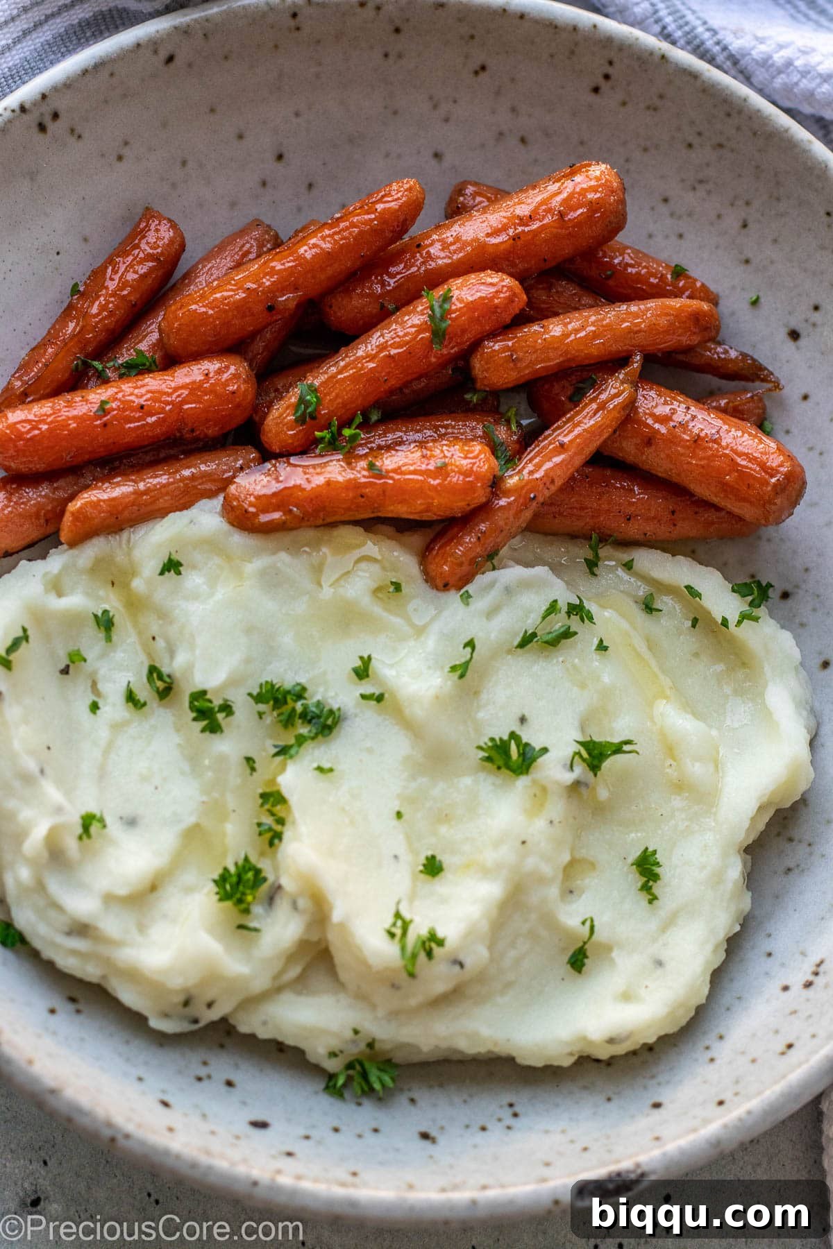 A serving of perfectly creamy mashed potatoes with vibrant carrots, illustrating the versatility of this side dish.