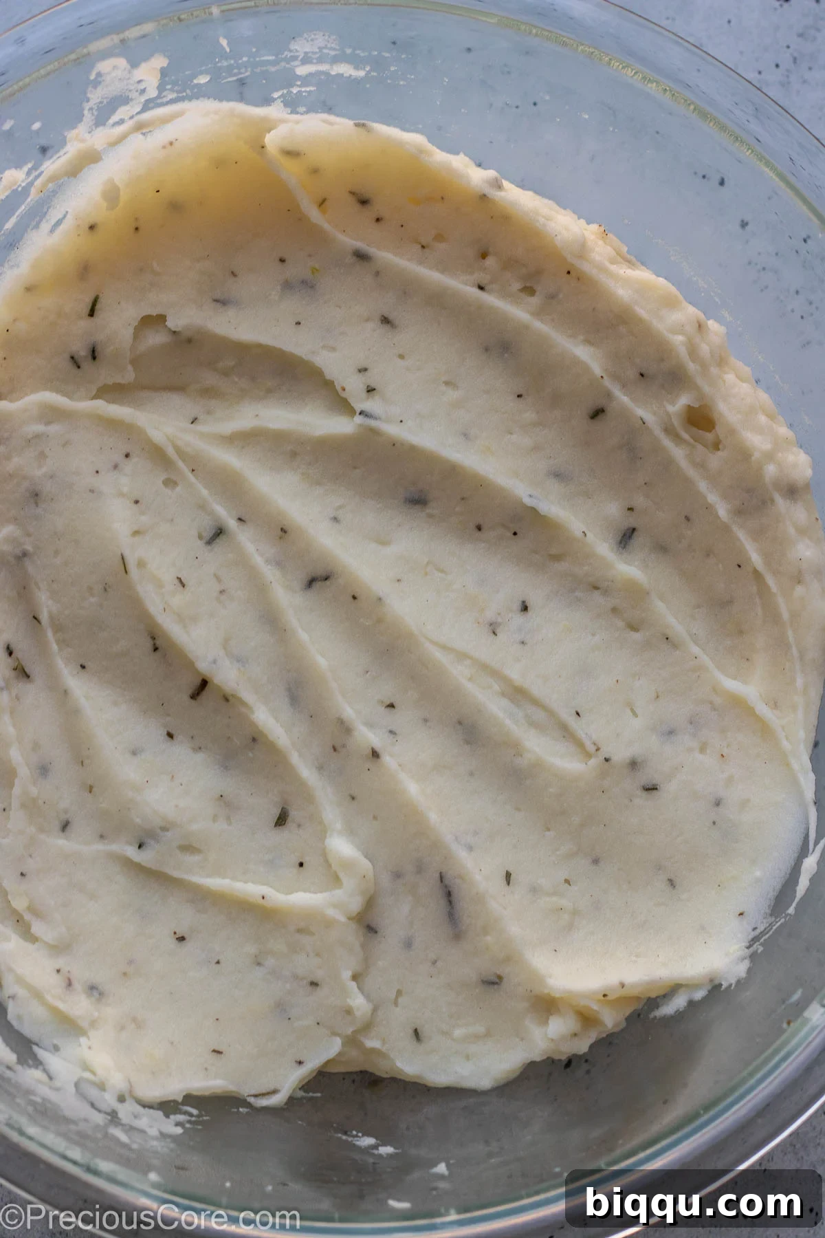A large mixing bowl filled with freshly prepared Rosemary Garlic Mashed Potatoes, perfectly mixed, creamy, and ready to be served.