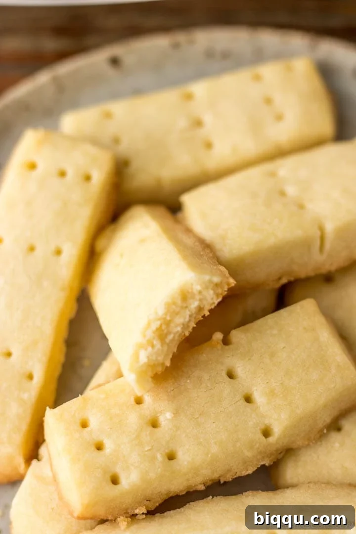 Effortless Homemade Shortbread 4 Shortbread cookies with one bitten to reveal crumbly texture