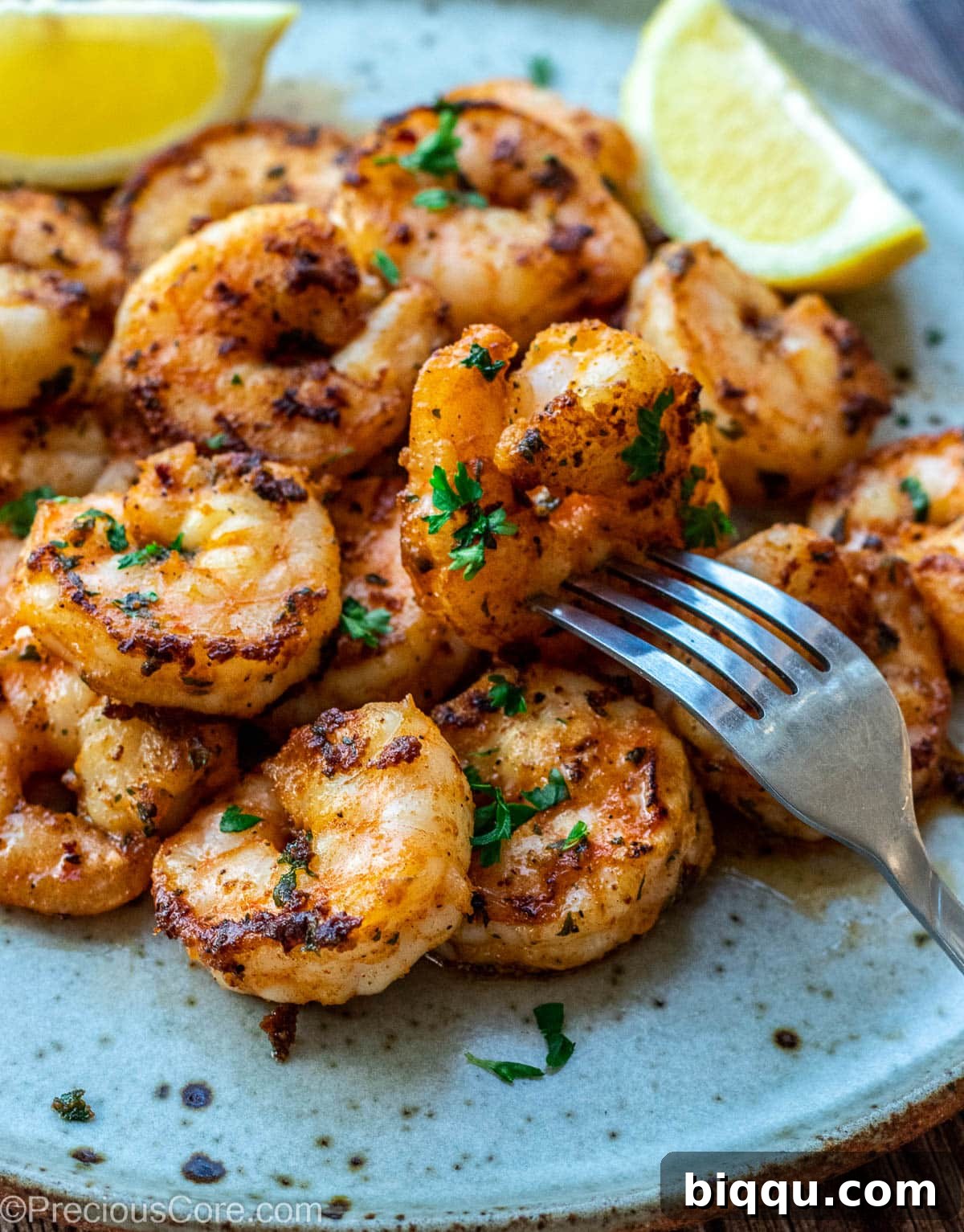 Juicy, perfectly cooked shrimp, artfully arranged on a plate and garnished with bright lemon wedges, ready to serve.