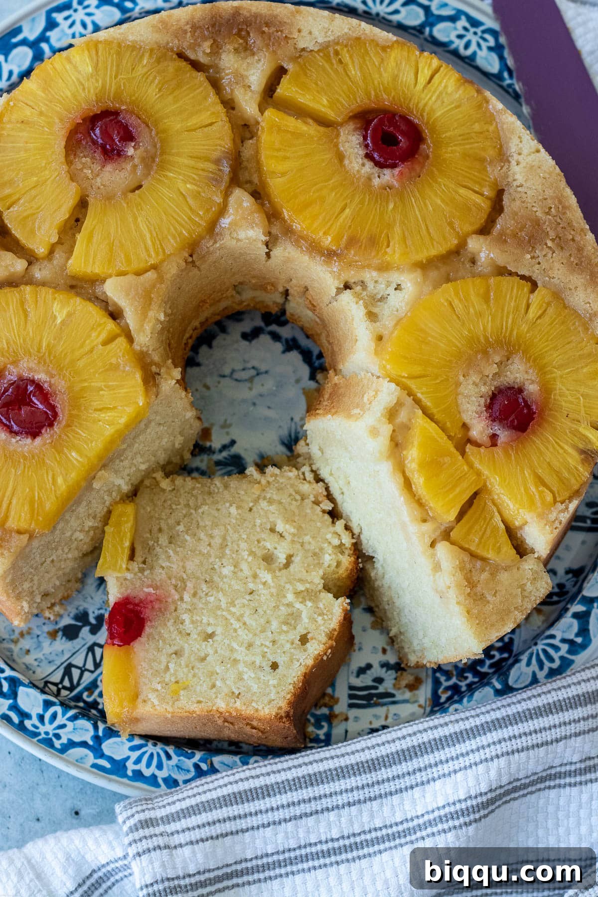 A beautifully baked Pineapple Upside Down Pound Cake garnished with pineapple rings and maraschino cherries.