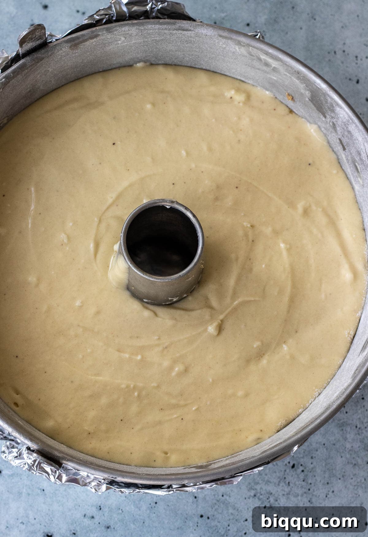 Smooth pound cake batter evenly distributed in the prepared bundt baking pan.