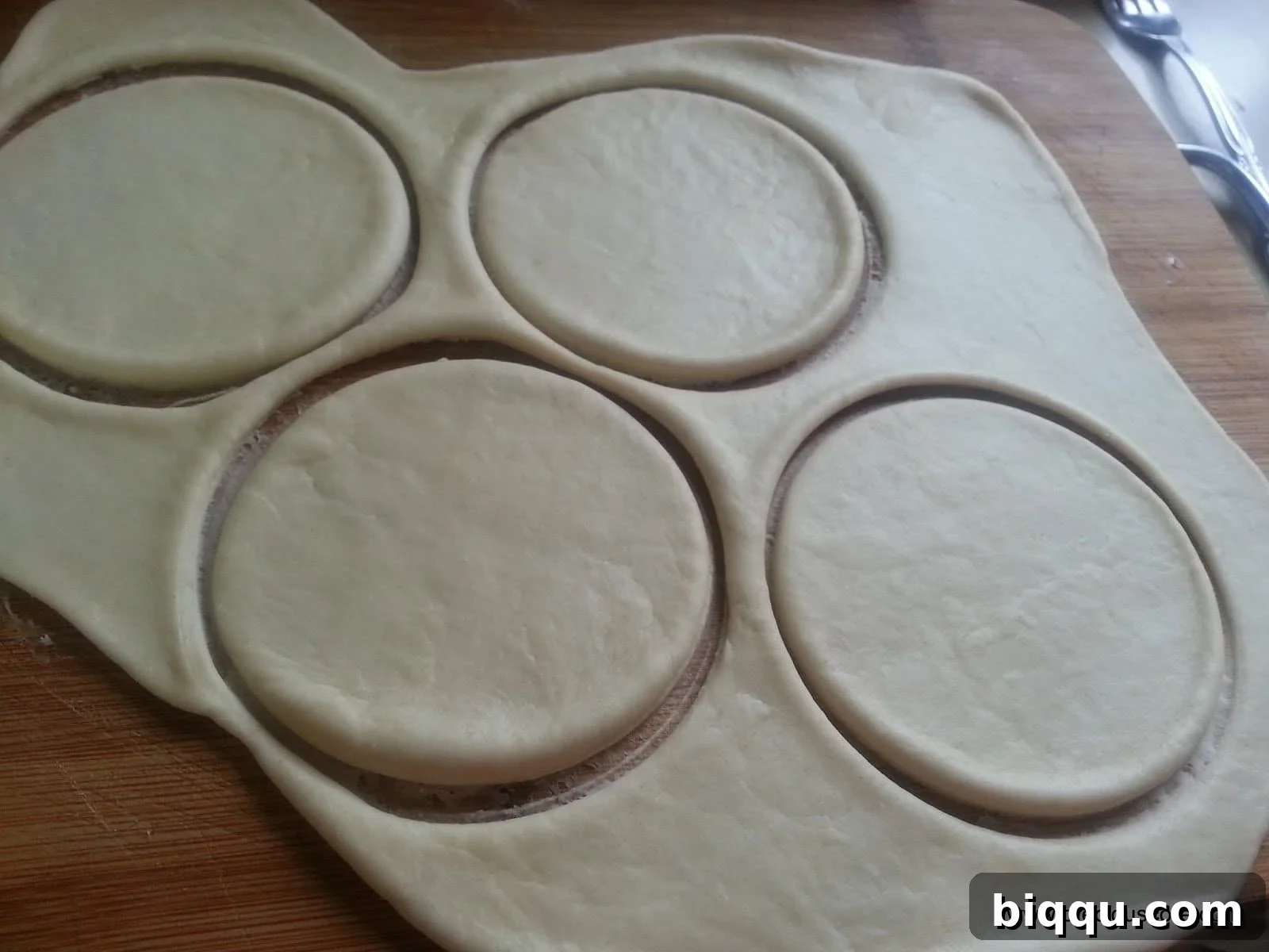 Multiple dough circles neatly arranged on a floured surface
