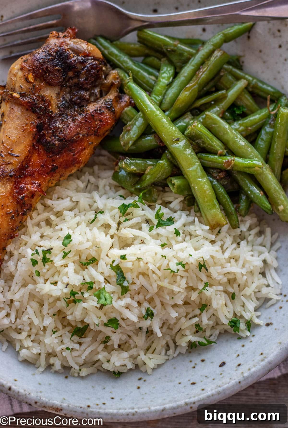 A beautifully plated meal featuring a generous portion of fluffy garlic herb rice, accompanied by vibrant green beans and succulent roasted turkey, showcasing a perfect holiday spread.