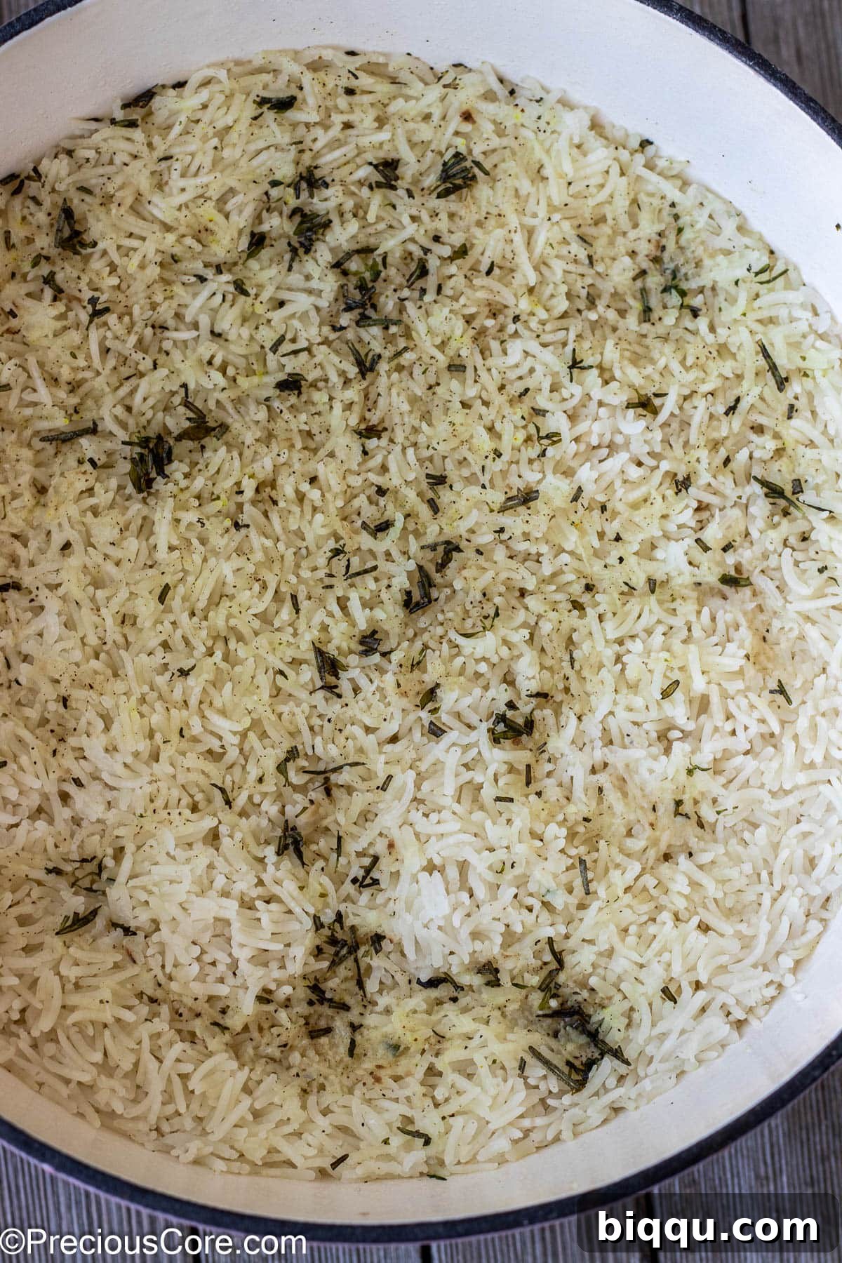 Fluffy, perfectly cooked rice infused with garlic and herbs, steaming gently in a covered pot, indicating it's just finished the simmering phase and is ready for the final touches.