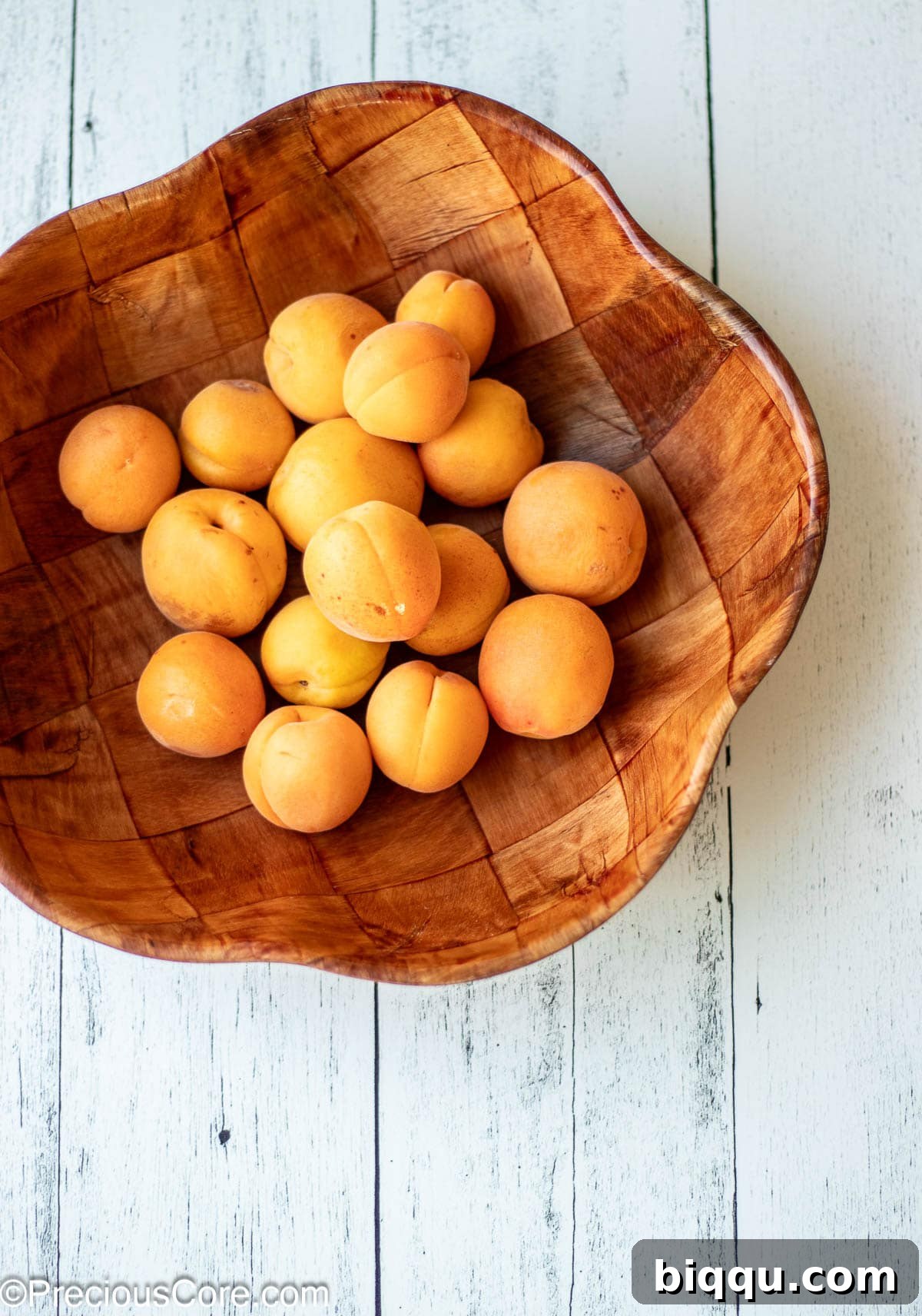 A wooden bowl of apricots.