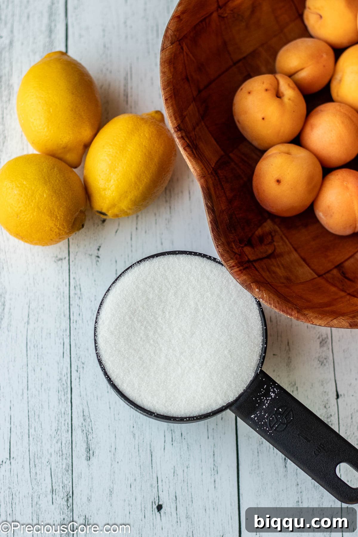 Apricots, lemon and sugar on a board.