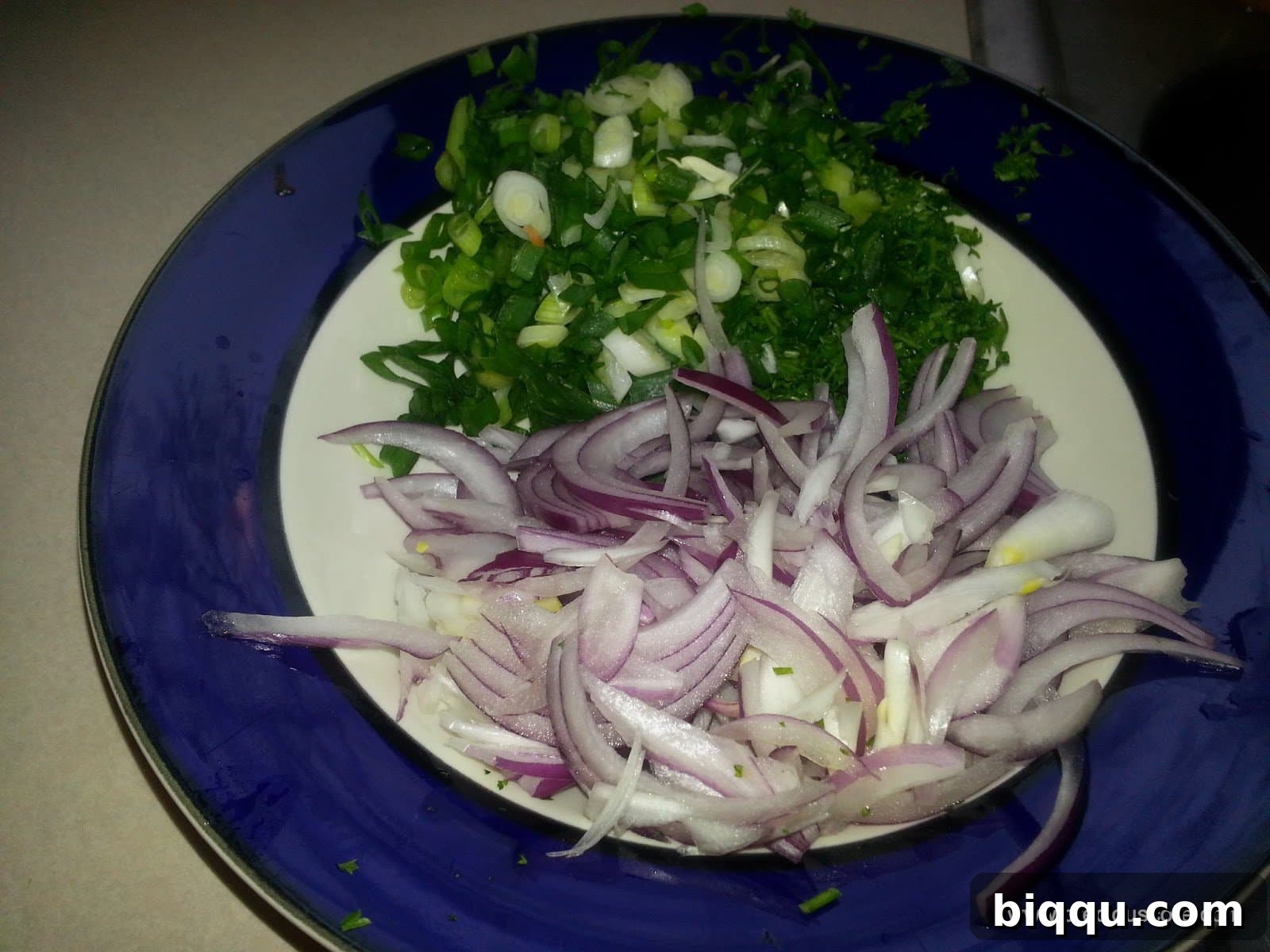 Finely chopped onions and fresh green herbs, ready to infuse flavor into the dish.