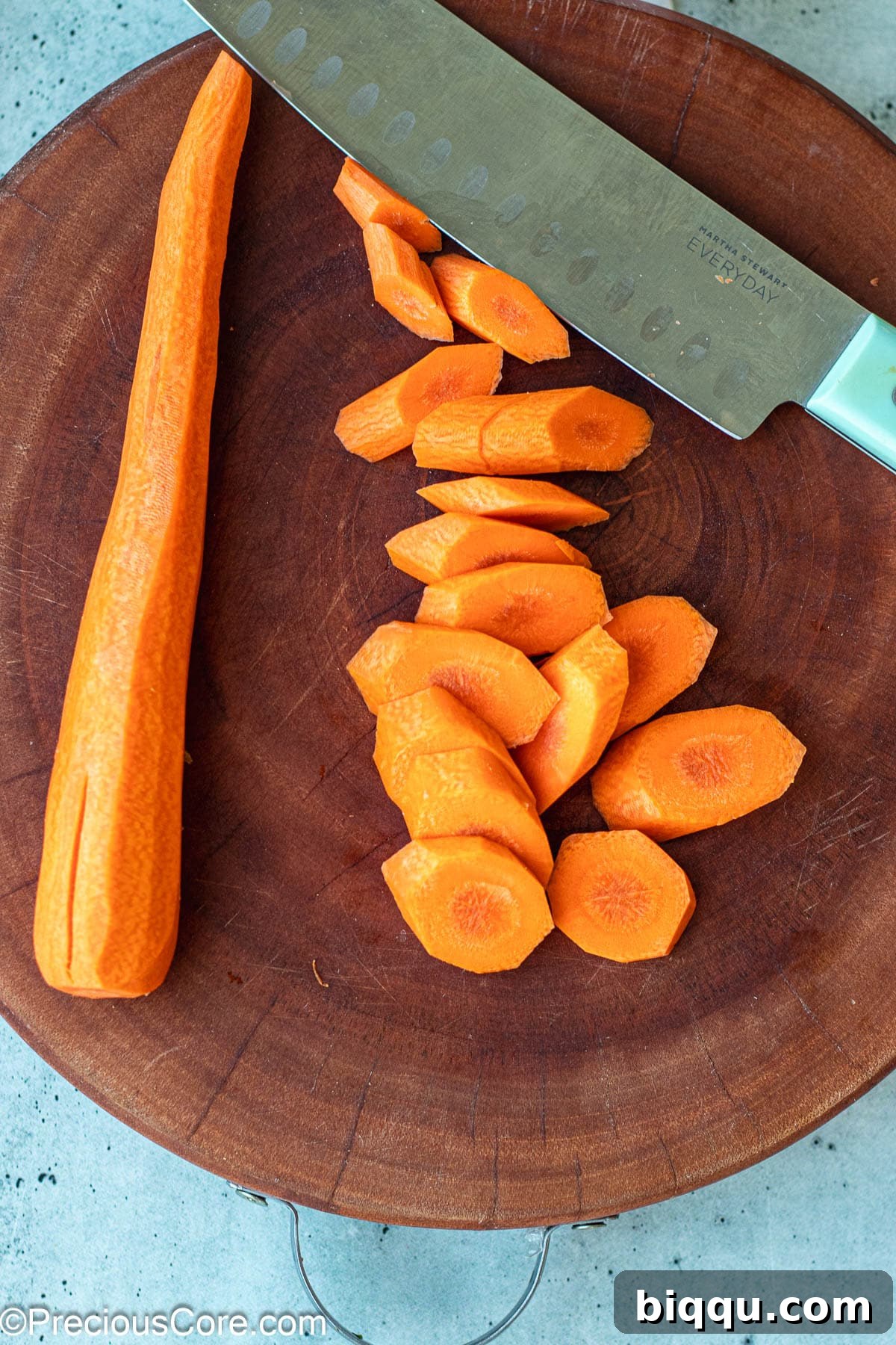 Diagonally cut carrots on a wooden chopping board, ready for frying.