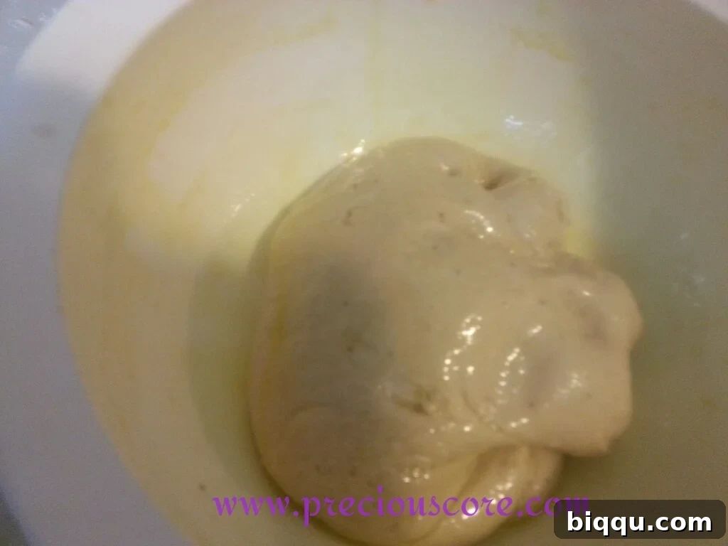 Bowl of dough covered with plastic wrap for rising