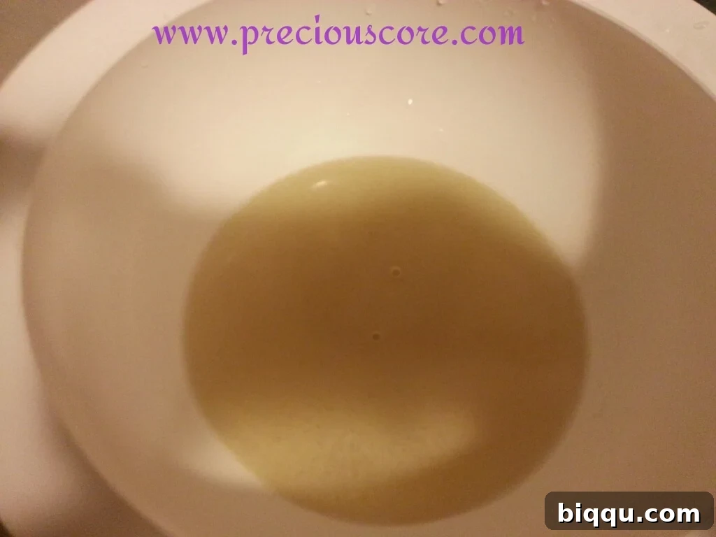 Yeast dissolving in warm water to activate, showing foam