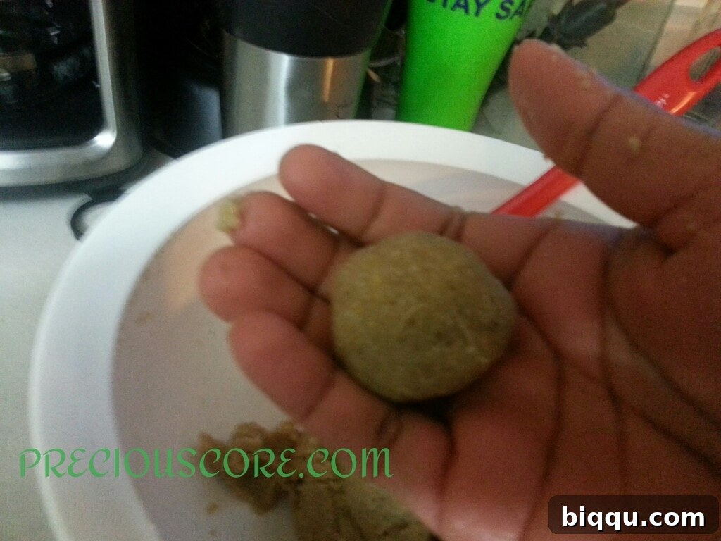 Small balls of Accra Banana batter being carefully placed into hot oil for frying