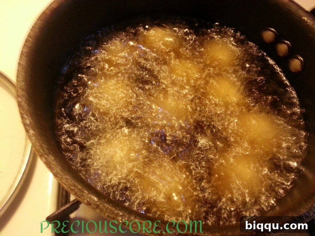 Accra Banana fritters frying in hot oil, turning golden brown