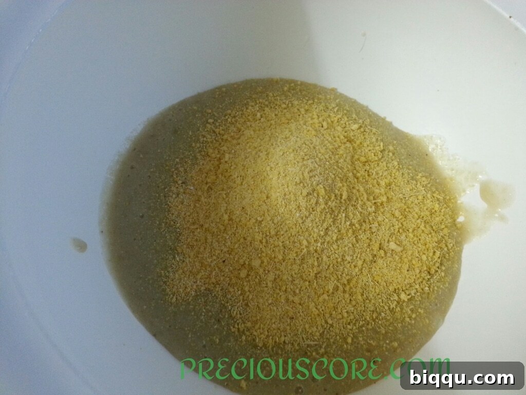 Garri and salt added to the banana mixture in a bowl, ready for stirring