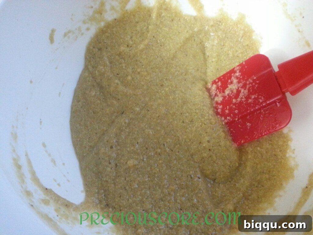 Close-up of the Accra Banana batter being stirred in a bowl, showing its thick consistency