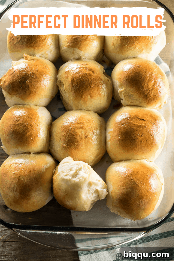 Perfectly risen and golden-brown sweet dinner rolls arranged on a wooden board, highlighting their soft texture.
