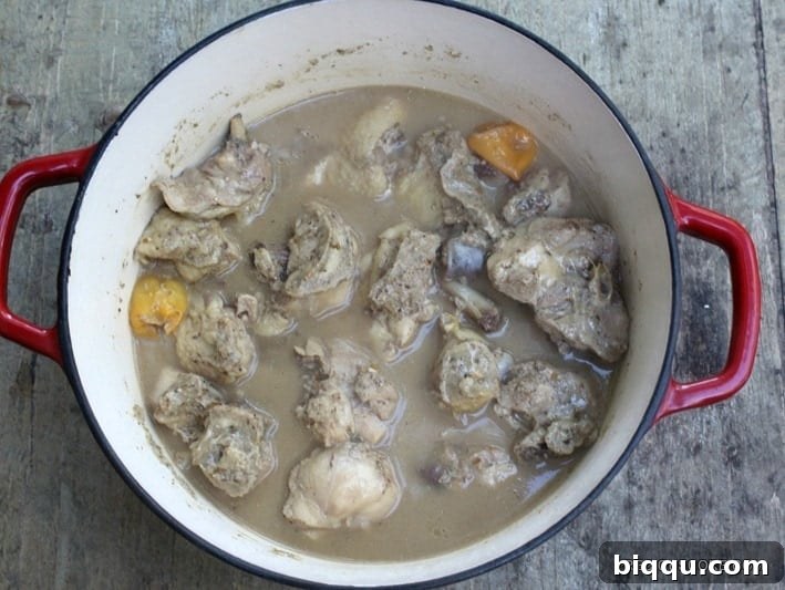 Chicken pepper soup simmering on the stove, broth enriching with flavor.