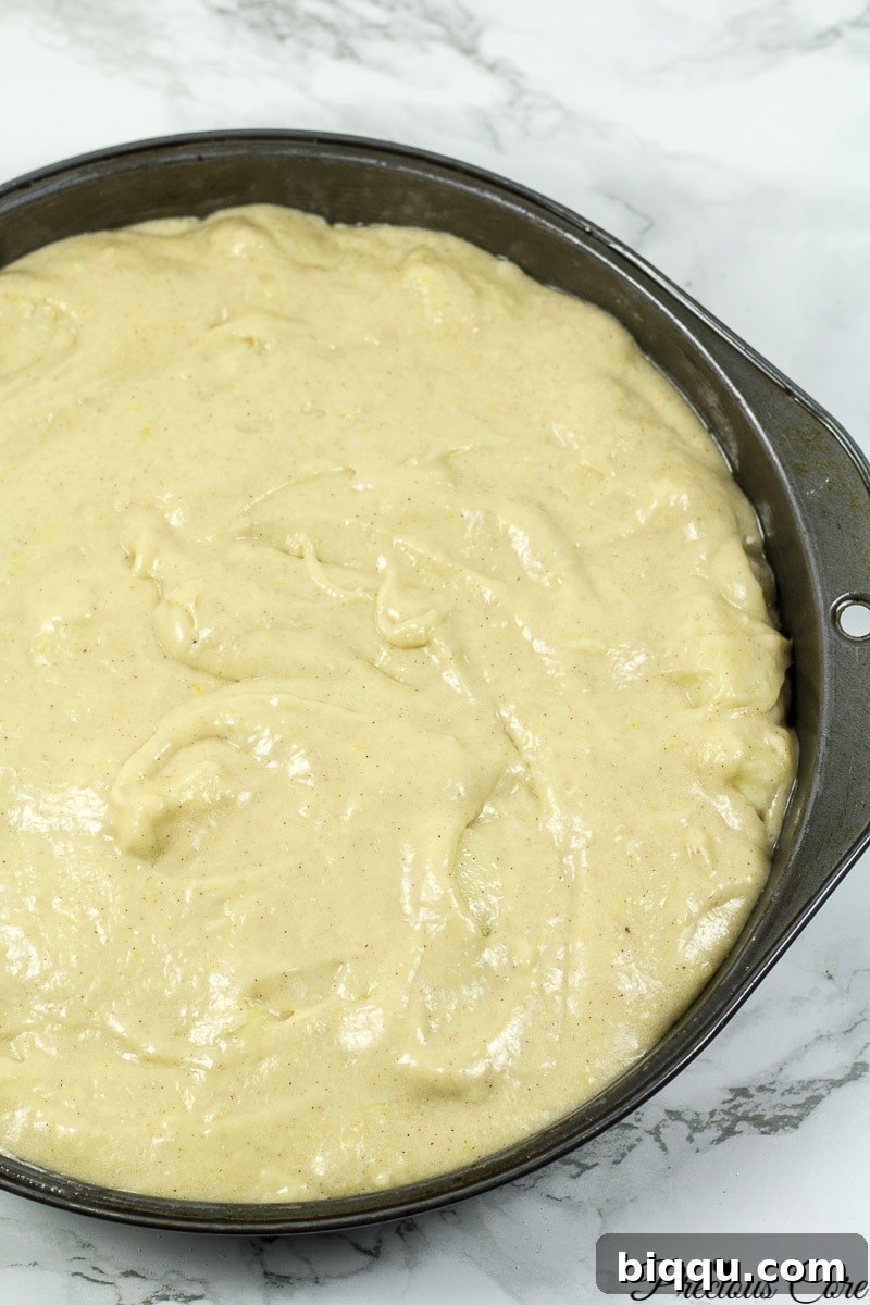 Cake batter poured into a greased baking pan, ready for the oven.