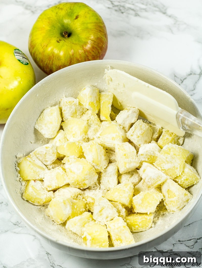 Chopped apple chunks evenly tossed with flour, ready for the cake batter.