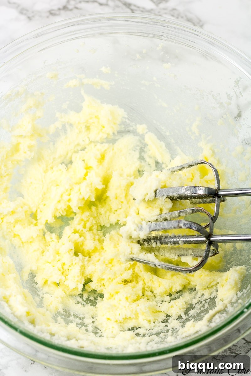 Creaming butter and sugar together in a mixing bowl with an electric mixer.