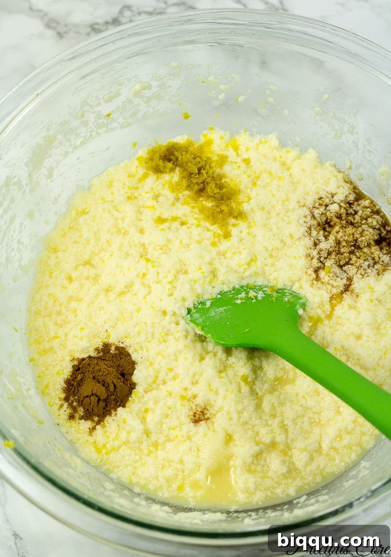 Wet ingredients including milk, vanilla, lemon zest, and cinnamon added to the mixing bowl.