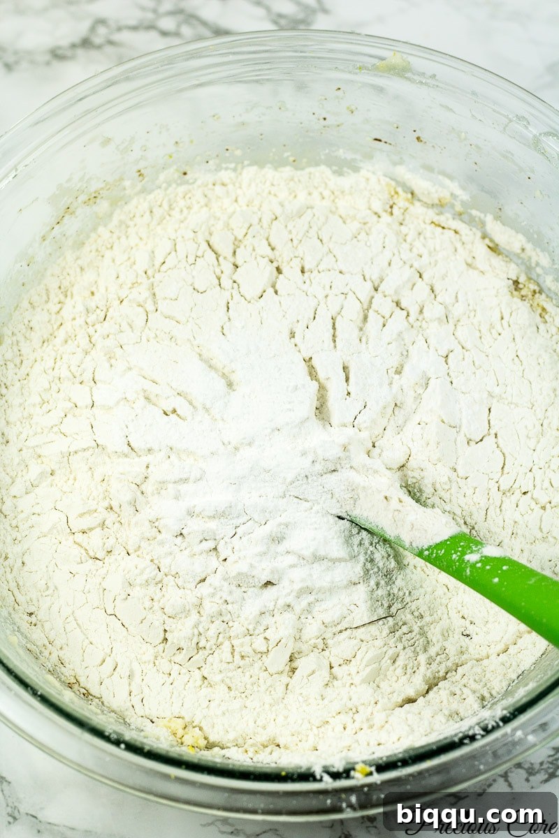 Flour and other dry ingredients being folded into the wet batter.