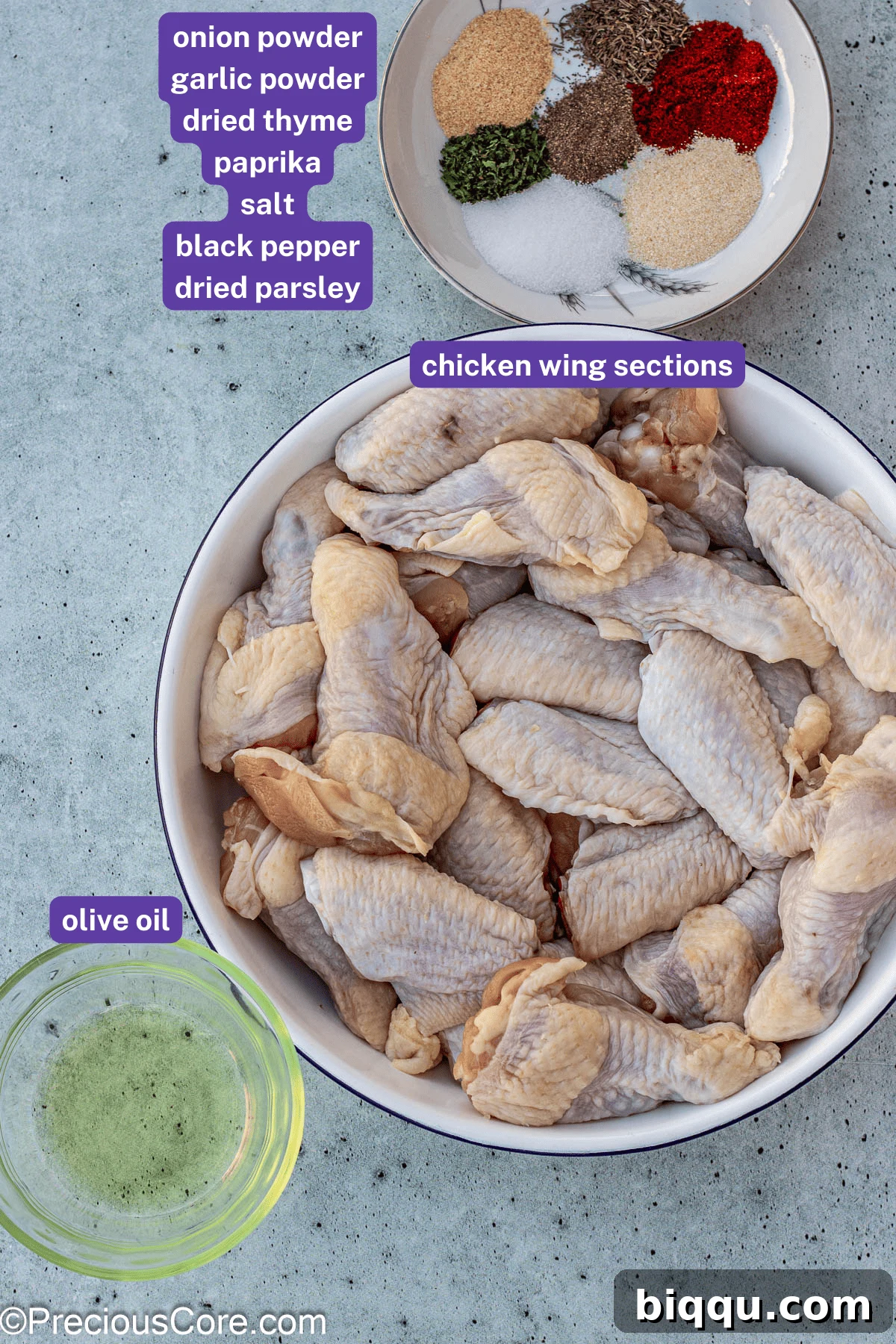 Collection of dry rub ingredients, including olive oil, salt, pepper, garlic powder, onion powder, dried thyme, parsley, and paprika, laid out on a kitchen counter.